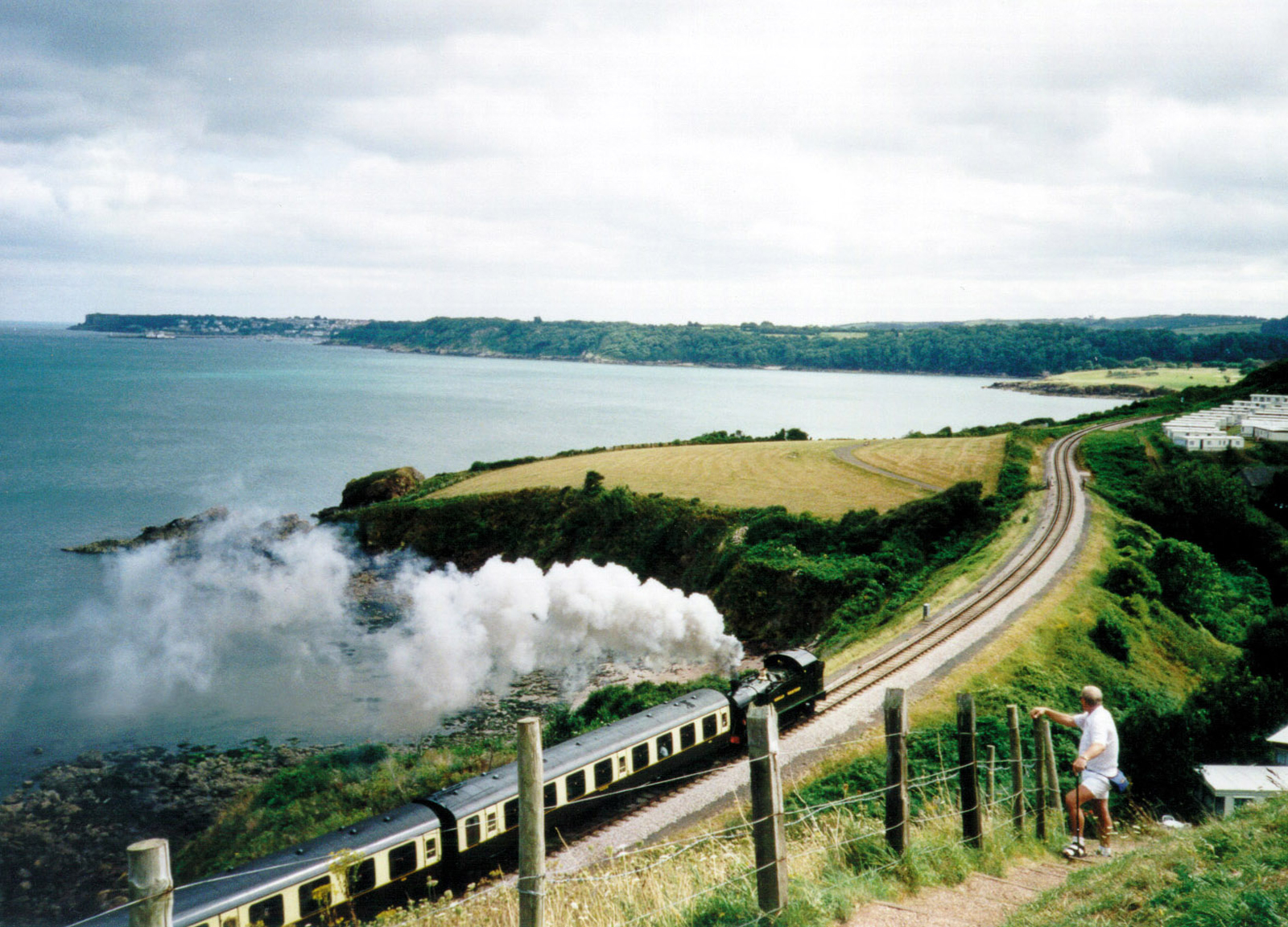 A romantic view of a steam train passing along the coast between Paignton and Dartmouth