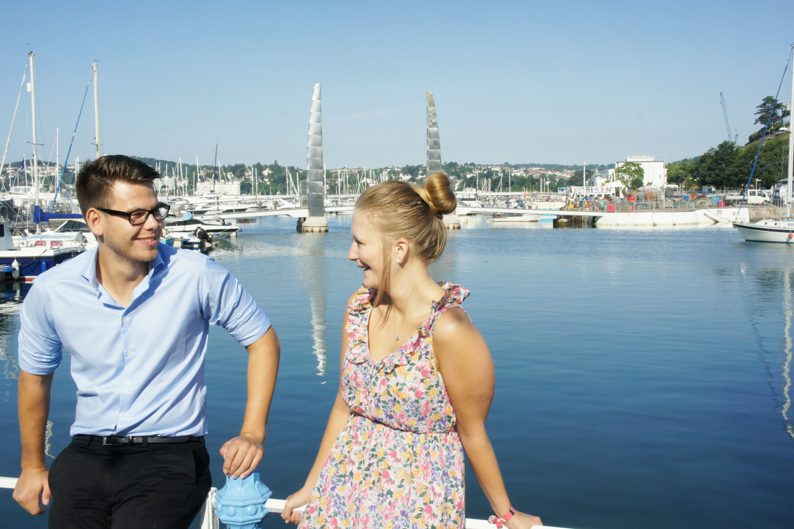 Young romantic couple sitting by Torquay harbour